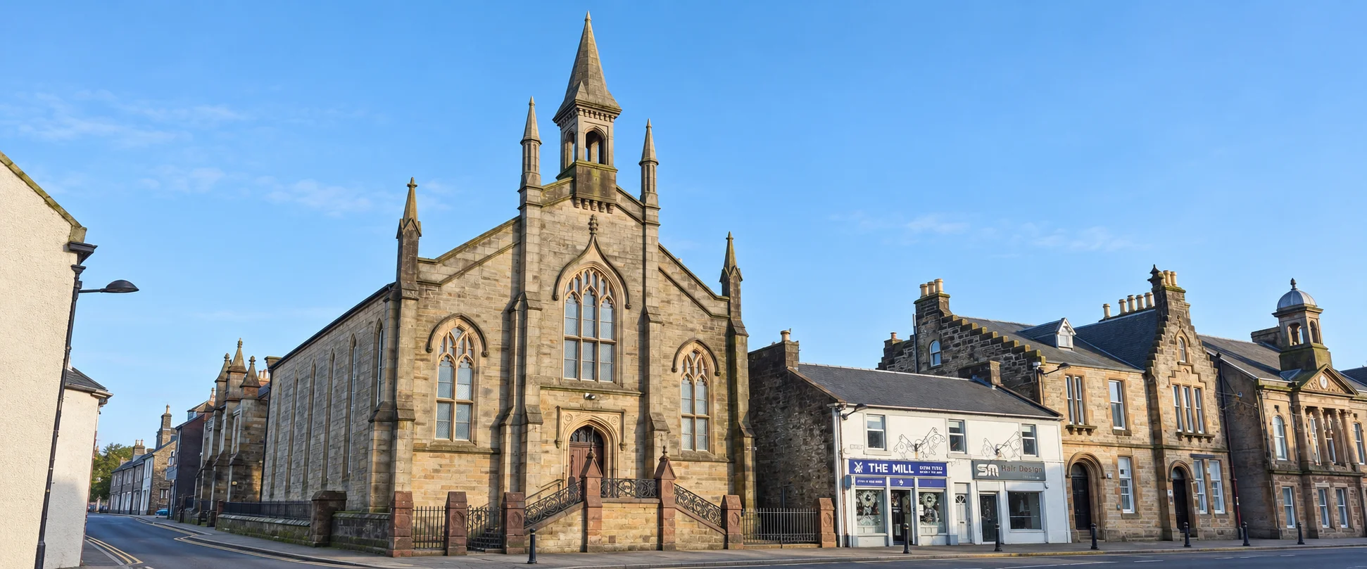 Dalry Parish Church and the surrounding town buildings in warm daylight